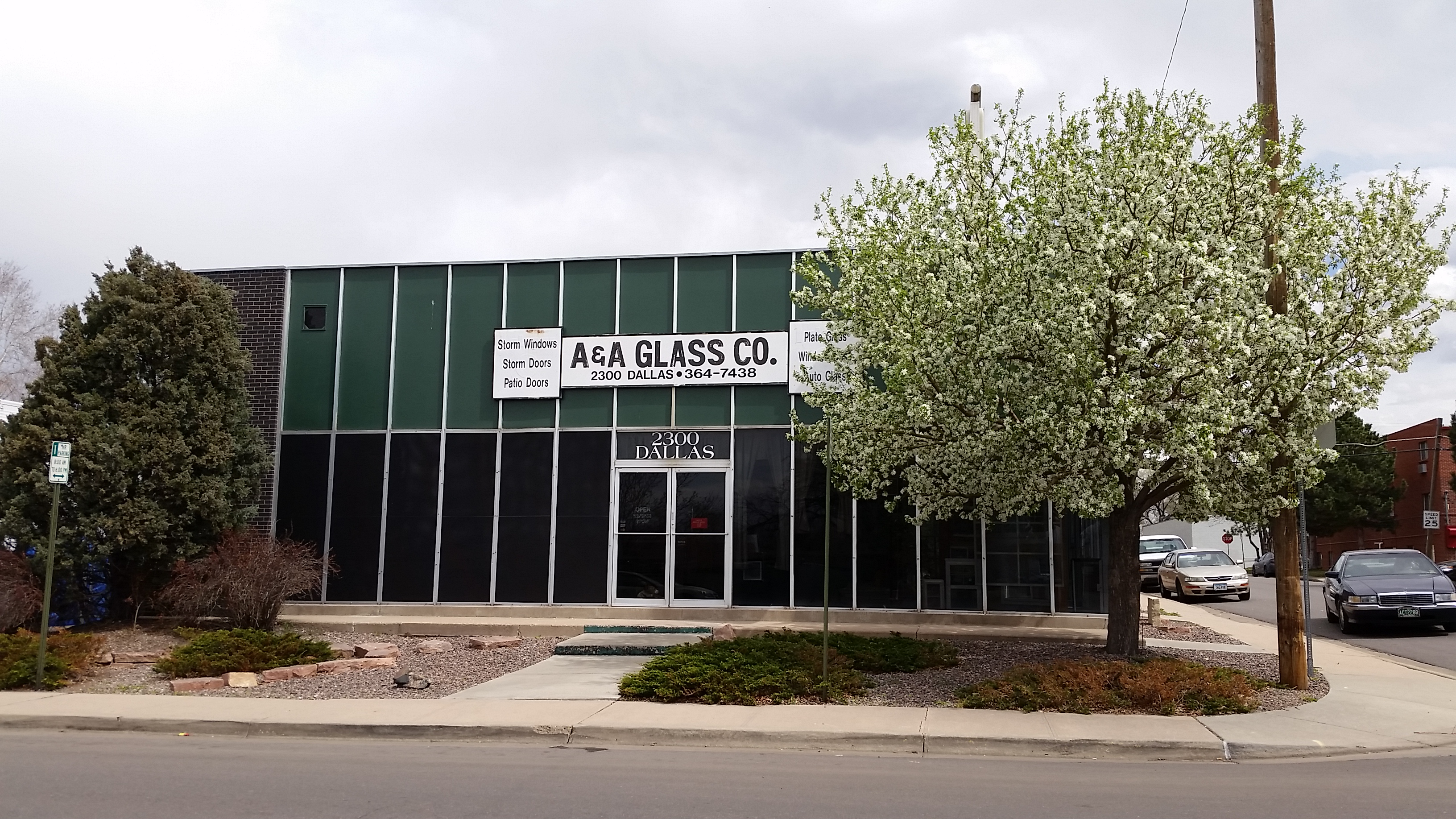 A&A Glass Co. building exterior on Dallas Street, Aurora - glass-front industrial workshop with spring blossoms